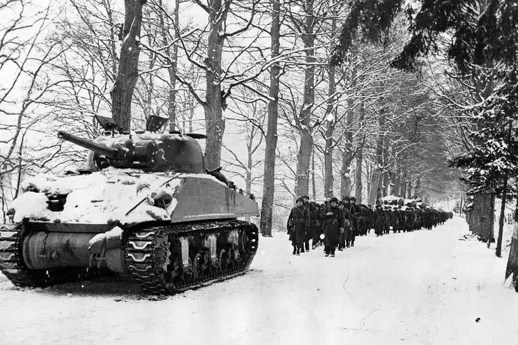 Museum of the American G.I in College Station, Texas - Image of Sherman tank leading soldiers down a snow covered road during the Battle of the Bulge