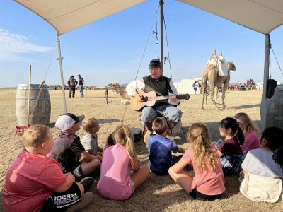 Children in tent learning about camels